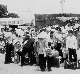 Thousands of South Vietnamese people congregate outside the American Embassy in Saigon hoping to get through the gate guarded by U.S. Marines and climb aboard U.S. helicopters that would take them to safety. This was during the final days before North Vietnamese and Viet Cong troops marched into the capital city.